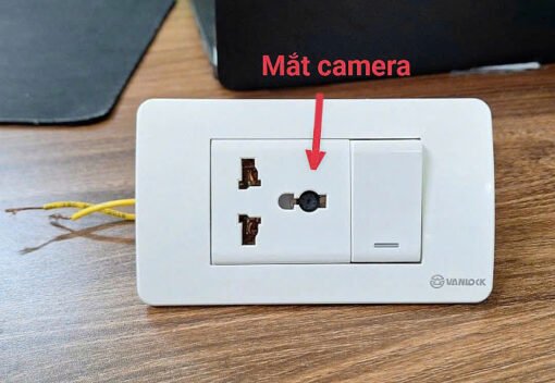 Ổ Cắm Điện Tích Hợp Camera – Mũi tên chỉ vị trí camera trên mặt ổ cắm điện
